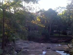 Rotsachtige stroompje met NAL-gebouw in de verte